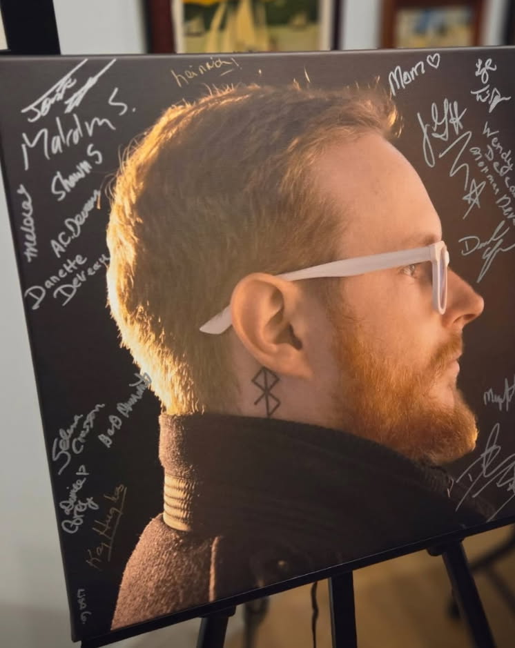 image of a man's profile on a poster with signatures surrounding it.